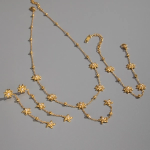 Elegant gold eight-point star jewelry set with necklace and earrings on grey background