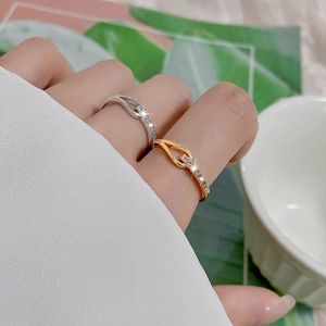 Close-up of knot-shaped adjustable rings in gold and silver with sparkling cubic zirconia