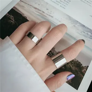 Close-up of minimalist wide and narrow polished stainless steel rings on a model hand