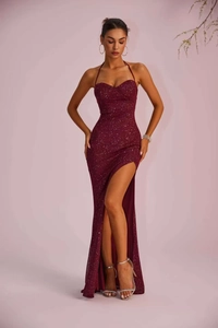 Full view of elegant burgundy sequin evening dress with spaghetti straps and high slit detail