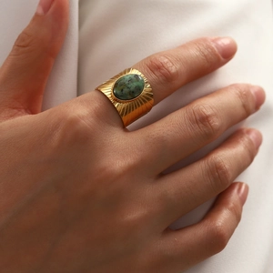 Detailed view of vintage gold-plated wide band ring featuring an oval turquoise stone