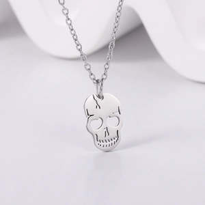 Macro shot of silver skull pendant with laser-cut crack details on thin steel chain