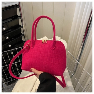 Detail of rose red crocodile pattern shell bag with elegant gold metal hardware