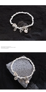 Close-up of silver beaded bracelet featuring heart, bunny and blessing character charms