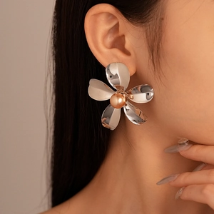 Macro detail of large silver metallic flower earring with a champagne pearl center