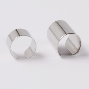 Polished silver stainless steel layered ear clips and leaf pendant cuffs on white background
