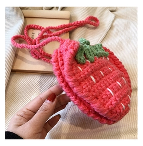 Nahaufnahme der rosa handgestrickten Erdbeer-Tasche mit Fokus auf Textur und Webmuster