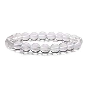 Close-up of clear round crystal beads on a minimalist stretch bracelet with white background