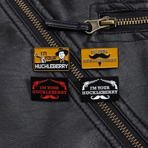Detail of western-style I'm Your Huckleberry metal badges on black leather jacket