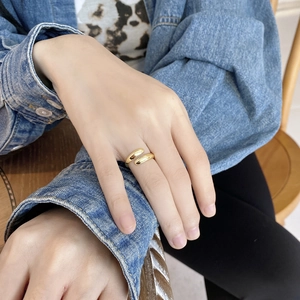 Detailed close-up of a minimalist gold adjustable bypass ring worn on a finger