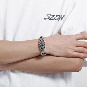 Close-up of vintage silver bracelet with Gothic floral relief on wide metal links