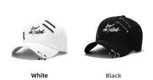 Detail of baseball caps with Keep the faith embroidery and silver metal rings on the brim