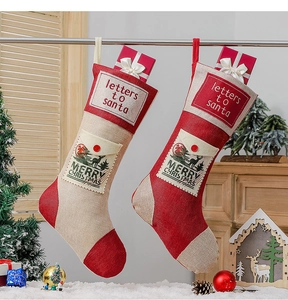 Detail of red and beige burlap Christmas stockings with letters to Santa and deer patterns