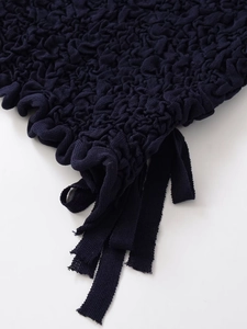 Detail of navy blue bubble textured knit fabric showing high elasticity and 3D pattern