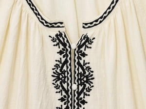 Détail du col en coton et lin crème avec broderie florale ethnique noire sur le devant