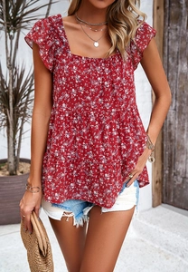 Detail of red floral sleeveless top with ruffle cuffs and tiered hem in a resort setting