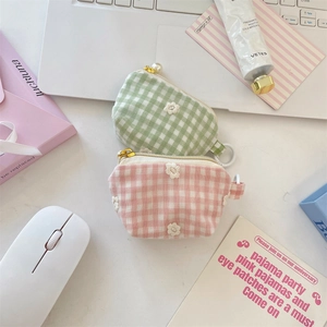 Close-up of gingham coin purses with daisy embroidery and elegant pearl zipper detail