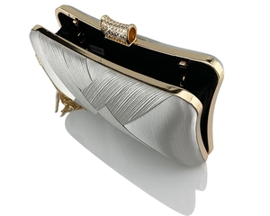 Detail of silver satin clutch with gold frame, rhinestone clasp, and interior lining