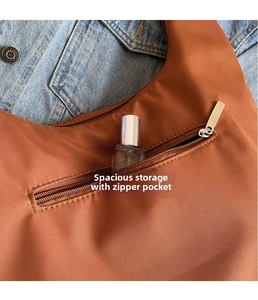 Detail of caramel nylon tote bag showing front zipper pocket for perfume storage