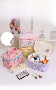 Close-up of quilted makeup bags with cute bow embroidery in pink, yellow and purple