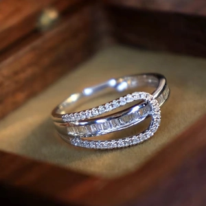 Macro detail of silver ring with baguette and round zircons on vintage velvet box