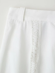 Gros plan d'un pantalon en lin blanc avec dentelle délicate et passants de ceinture