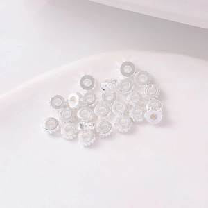 Dettaglio di distanziatori a ruota dentata argentati per la creazione di gioielli fai da te