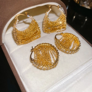 Detailed close-up of 18k gold plated tassel earrings with white zircon in a jewelry box