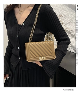 Detail of khaki quilted crossbody bag with golden chain strap and twist lock