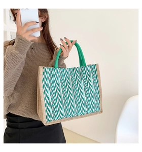 Detail of green wavy striped woven tote bag with durable braided handles and textured fabric