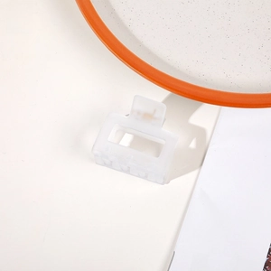 Macro detail of white matte square hair claw clip with minimalist spring mechanism
