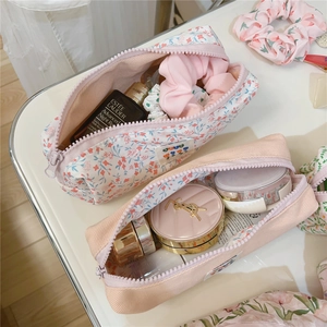 Detailed view of floral cotton and pink ribbed pouches showcasing large storage capacity