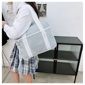 Detail of light grey JK uniform bag with heart-shaped clear window and shoulder strap