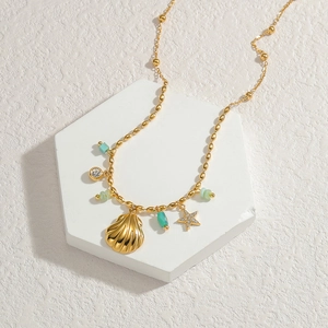 Macro view of 18k gold shell and turquoise stone pendants on a bead necklace chain