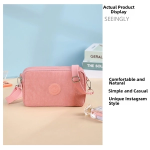 Dettaglio borsa a tracolla in nylon rosa con trama resistente all'acqua e cerniere multiple