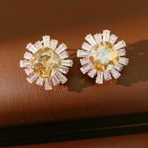 Macro shot of sunflower earrings with champagne center stone and marquise zircon accents