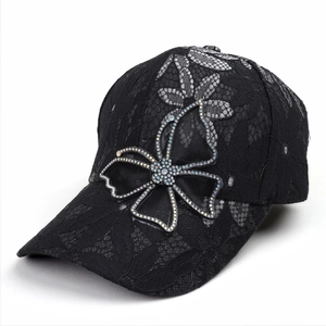 Detailed view of black lace baseball cap with large rhinestone bow decoration for women