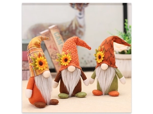 Detailed close-up of three autumn harvest gnomes with sunflowers and maple leaf decorations