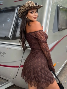 Détail d'une robe longue en dentelle marron foncé avec manches dénudées et chapeau léopard