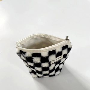 Detail of plush checkerboard pouch showing soft faux fur texture and silver metal zipper