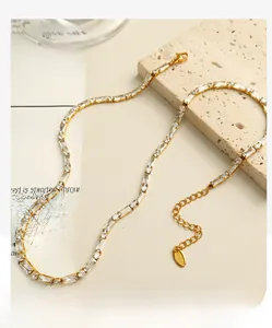 Detail of a gold-plated stainless steel tennis chain necklace with square and round zircons