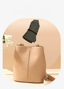 Chapeau de soleil pliable vert foncé rangé de façon compacte à côté d'un sac seau