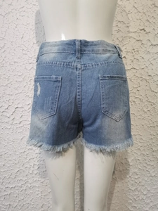 Vista de detalle de los pantalones cortos vaqueros azul claro con dobladillos deshilachados