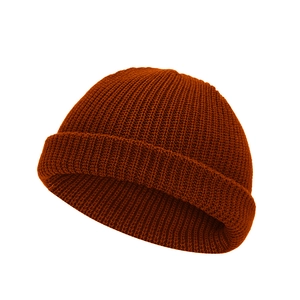 Detailed view of caramel orange ribbed knit texture and cuffed edge of the beanie