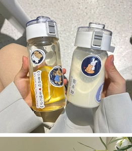 Detail of portable plastic water bottles with cartoon bear stickers and tea infuser lids