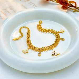 Gold double-layer butterfly bracelet with rhinestones on white ceramic tray