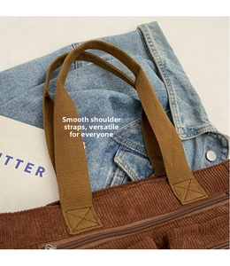 Close-up of brown corduroy shoulder bag with reinforced stitching and smooth strap detail