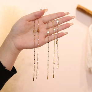 Detail of gold sun charm bracelets with colorful beads and adjustable chain on model hand
