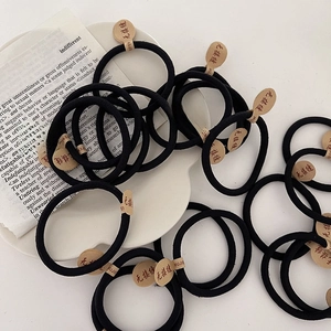 Élastiques à cheveux noirs sans couture sur assiette blanche en porcelaine style ins
