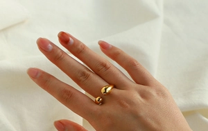 Vue détaillée d'une bague ajustable en acier doré avec motif en forme de goutte